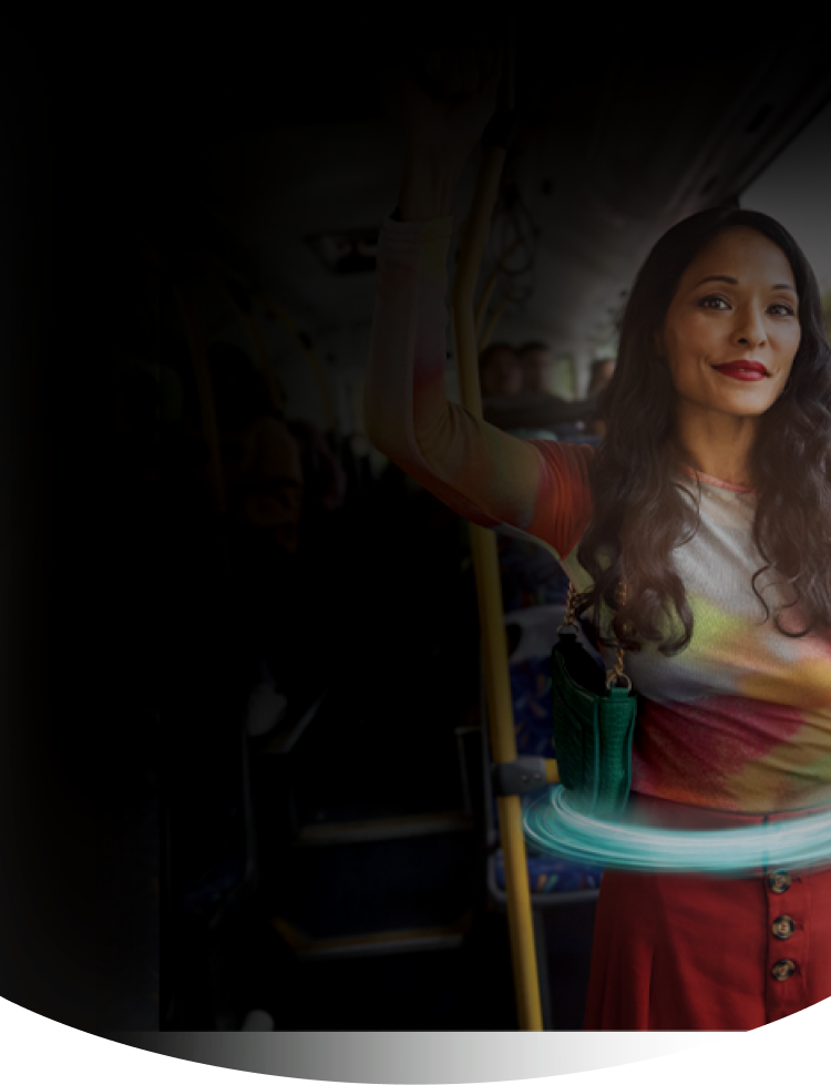Woman standing on a bus holding onto a railing with a blue ring around her stomach