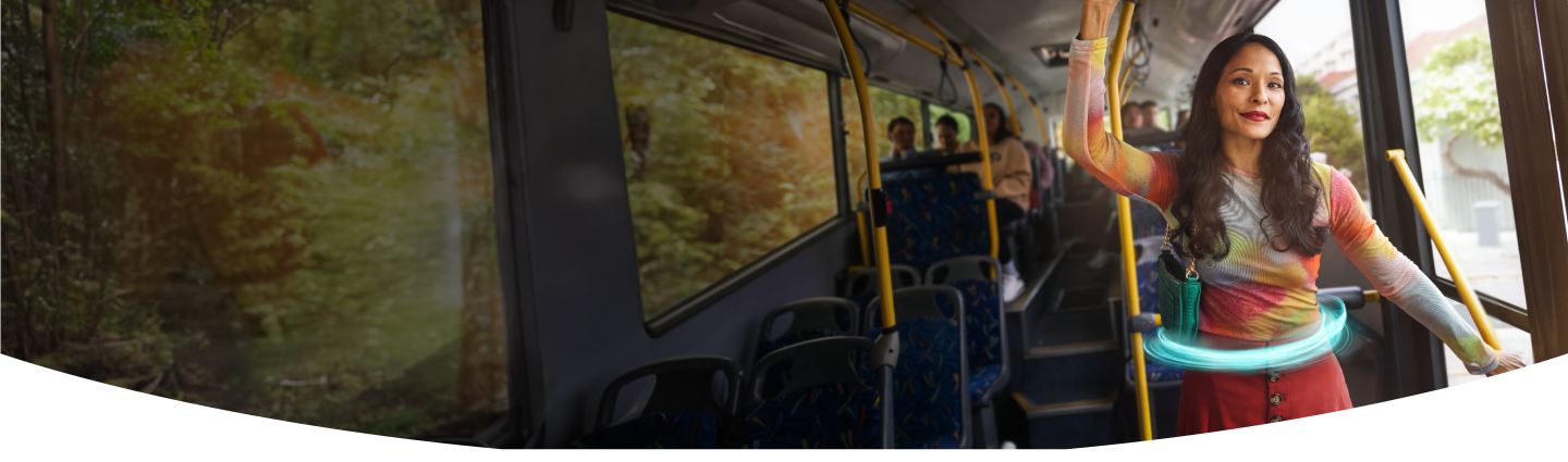 Woman standing on a bus holding onto a railing with a blue ring around her stomach