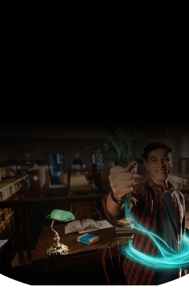 Man in the library smiling while holding up a plant with a blue ring around his stomach