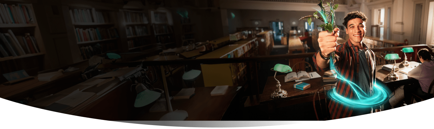Man in the library smiling while holding up a plant with a blue ring around his stomach