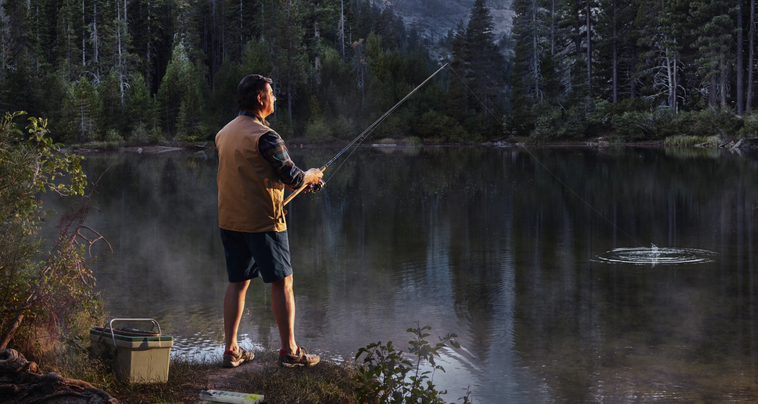 Man fishing on a lake in a wooded area