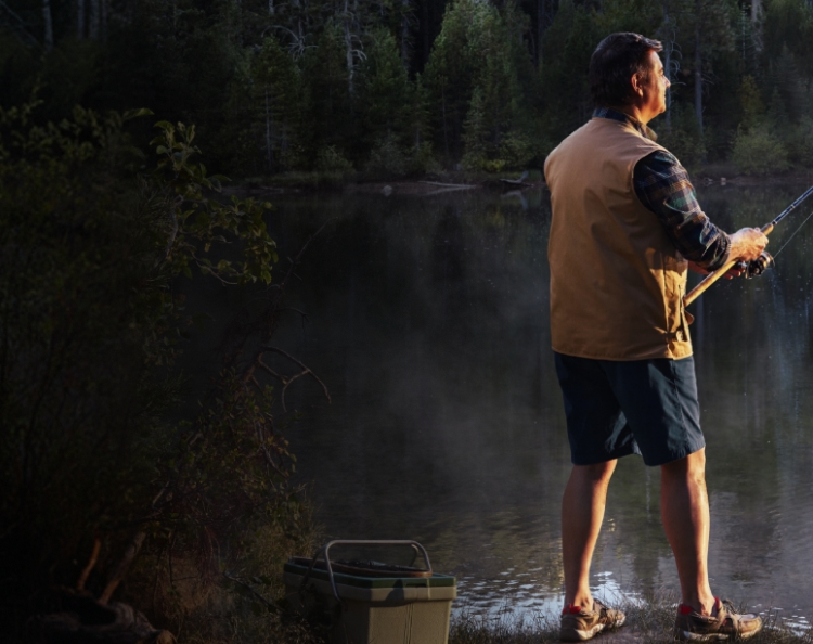 Man fishing on a lake in a wooded area