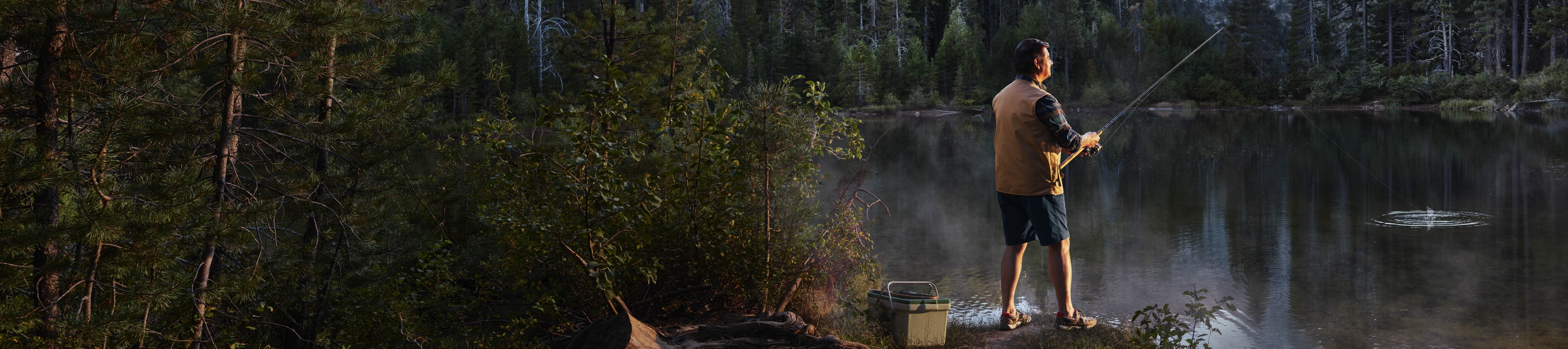 Man fishing on a lake in a wooded area