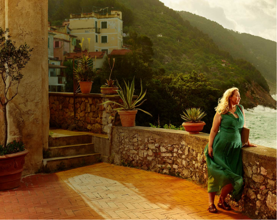 Woman looking out into the distance with water and mountains in the background
